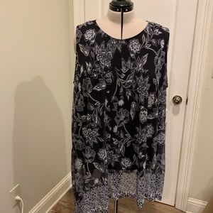 Sleeveless black and white floral blouse.